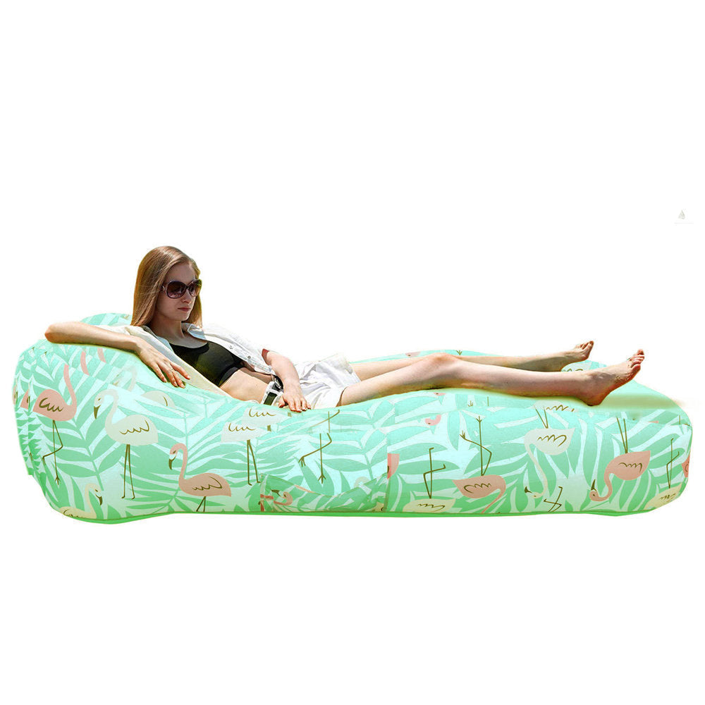 Inflatable Pool Float Sofa – Portable Swimming Pool & Beach Lounger A woman reclines on a mint green inflatable lounger with a tropical flamingo and palm leaf print. A small inset at the top right shows the same item carried on a backpack.