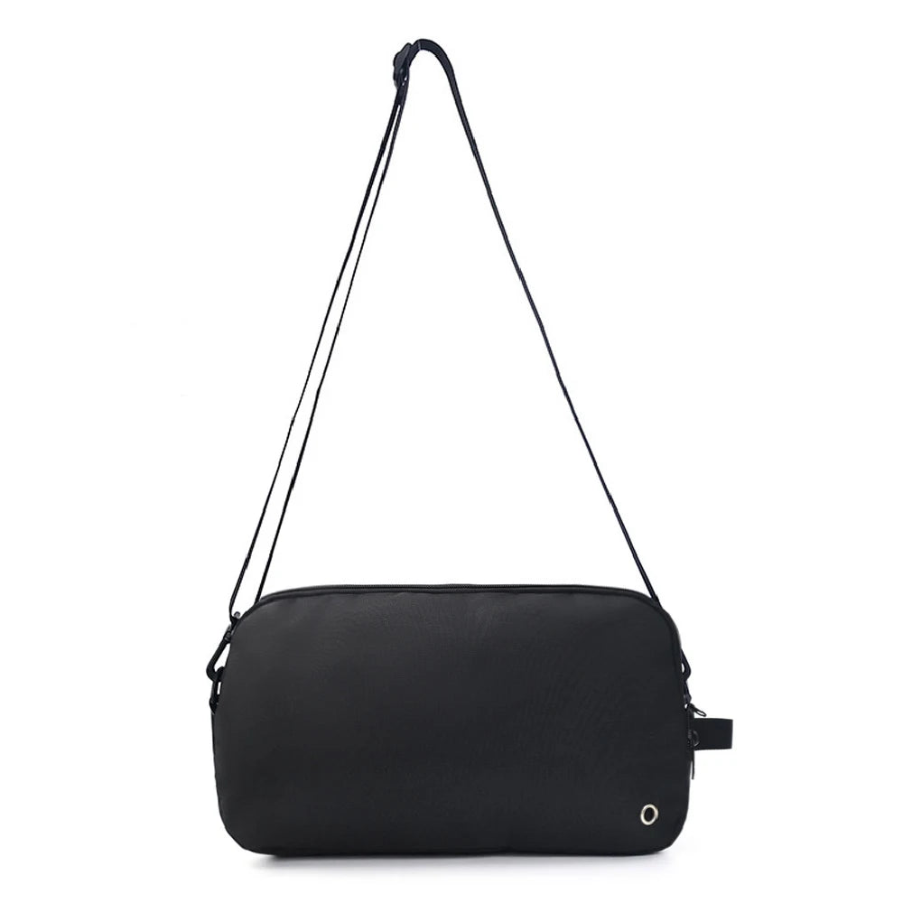 Travel Shoe Pouch – Portable Shoe Organizer for Gym & Sports A black rectangular shoulder bag with a long thin strap and a small silver circular logo on the bottom right, shown against a plain white background.