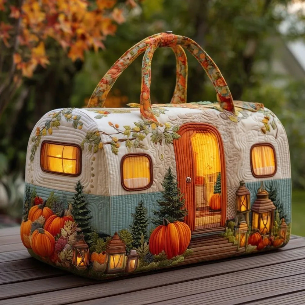 Christmas Quilted Travel Tote Bag – Vintage Camping Car Handbag A decorative vintage-style camping trailer lantern or light fixture placed on a wooden table outdoors. The white and teal trailer is decorated with autumn motifs including pumpkins, trees, lanterns, and a glowing warm window interior.