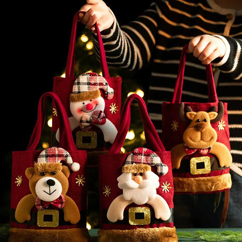 8-Pack Christmas Linen Gift Bags – Santa Candy & Treat Bags Four red Christmas-themed fabric tote bags with plush animal faces and holiday decorations, held by a person wearing a striped sweater against a dark background with warm blurred lights.