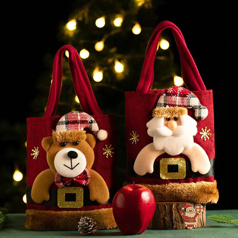 8-Pack Christmas Linen Gift Bags – Santa Candy & Treat Bags Two decorative bags with a teddy bear and Santa Claus design, placed against a blurred Christmas tree background.
