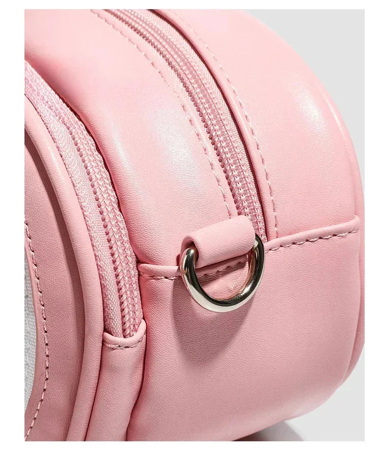 Apple-Shaped Crossbody Phone Purse – Lightweight Shoulder Bag Close-up of a light pink faux-leather backpack showing the curved zipper, stitching, and a silver metal D-ring closure.