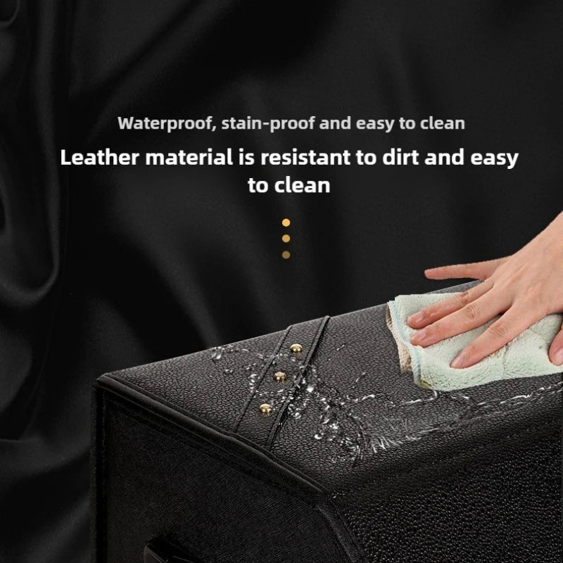 Leather Car Trunk Organizer – Large Capacity Foldable Storage Box A close-up of a black textured leather surface with water droplets being wiped away by a hand with a cloth. White text above reads 'Waterproof, stain-proof and easy to clean' and 'Leather material is resistant to dirt and easy to clean'.