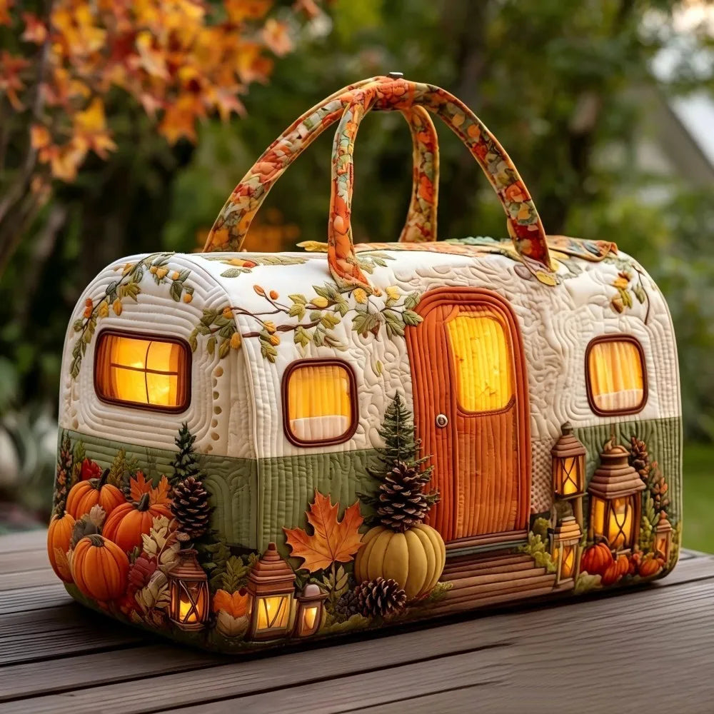 Christmas Quilted Travel Tote Bag – Vintage Camping Car Handbag A decorative camping trailer-shaped handbag with autumn-themed printed details, including pumpkins, lanterns, pinecones, and a warm glowing door and windows, shown outdoors on a wooden surface.