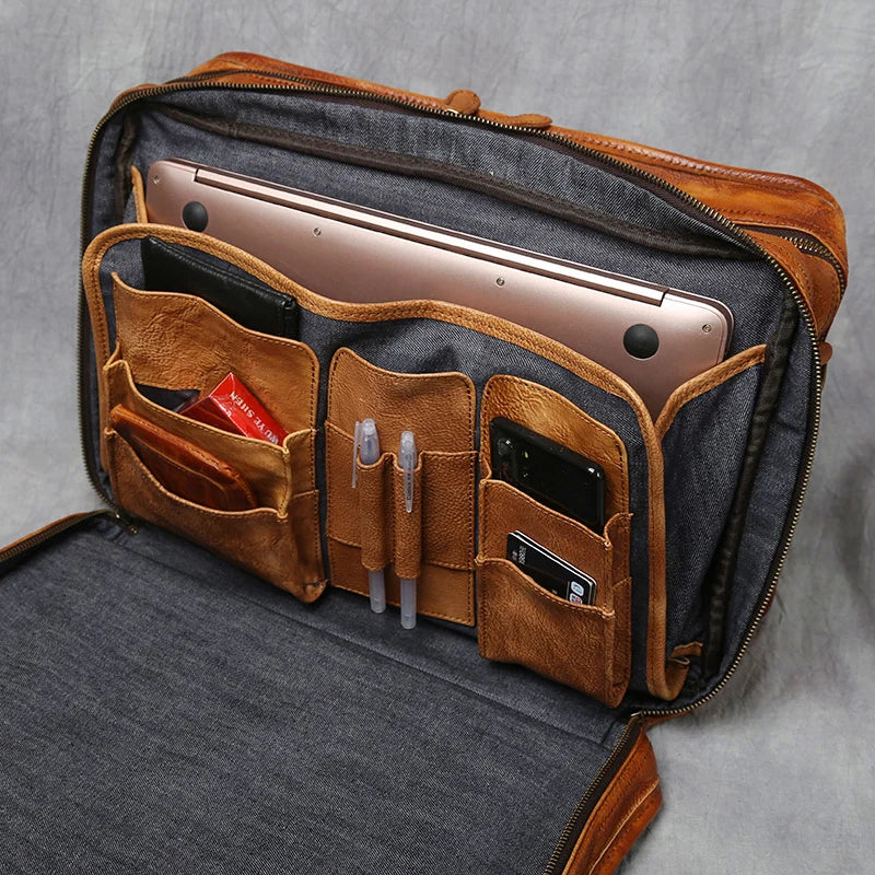 Genuine Leather Briefcase – Business Laptop & Travel Shoulder Bag An open brown leather laptop bag with a gray fabric interior, shown holding a laptop, phone, pens, and cards in its organized pockets.