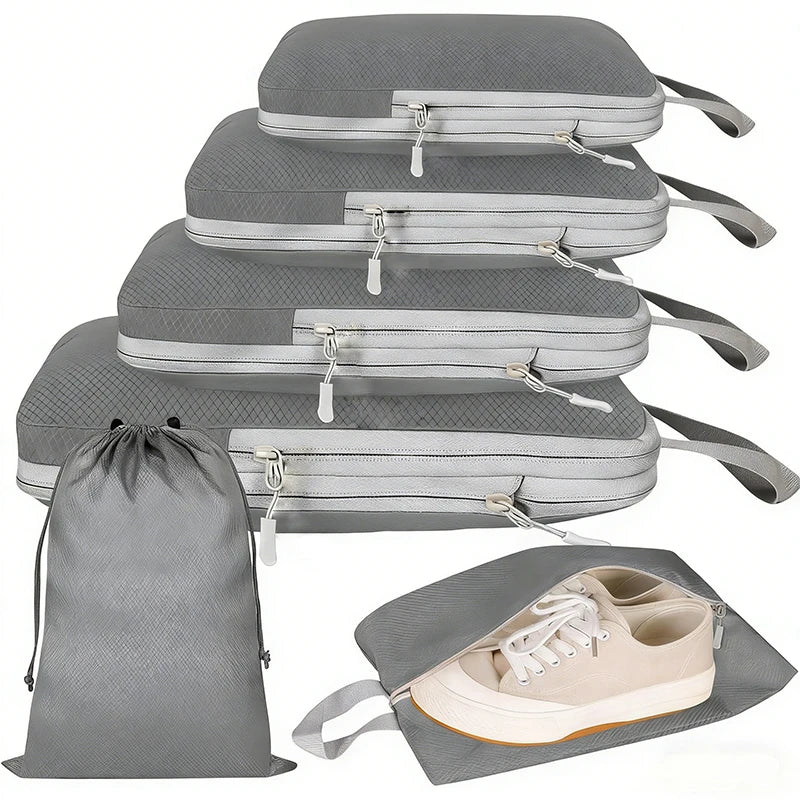 Compression Packing Cubes Set – Space-Saving Luggage Organizers Four gray packing cubes of different sizes stacked vertically, shown with a matching gray drawstring bag and one packing cube holding a pair of beige sneakers, on a white background.