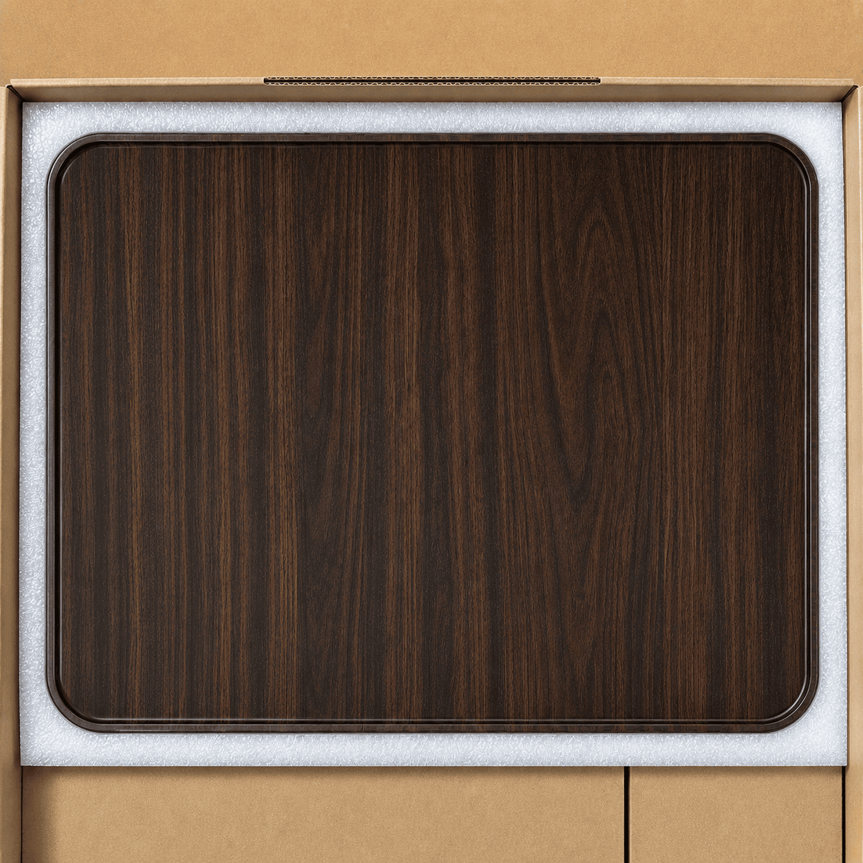 A dark brown wood grain rectangular tray with rounded corners, shown inside its light gray protective foam packaging insert against a tan cardboard background.
