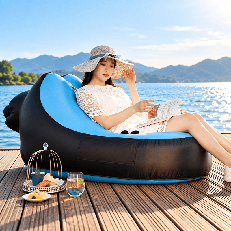 Inflatable chair with blue interior and black exterior, including a matching carrying bag, on a white background.