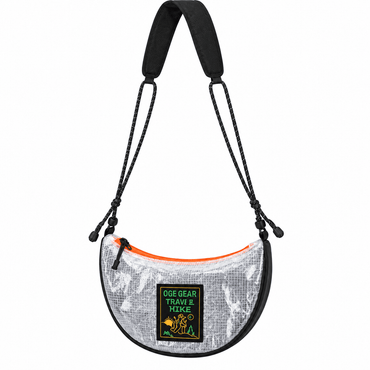 A crescent-shaped shoulder bag with a silver and black camouflage pattern, black trim, a black adjustable strap, and a bright orange zipper. A green and yellow 'OGE GEAR TRAVEL & HIKE' patch is attached to the front.