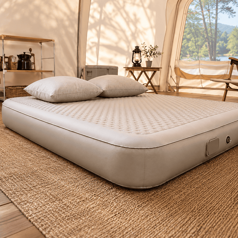 An inflatable camping bed by Sonuto, shown inflated on a clean white background with the brand logo in the top-left corner. The bed is a light beige/cream color with a quilted diamond-patterned top surface and a smooth, rounded bottom border.