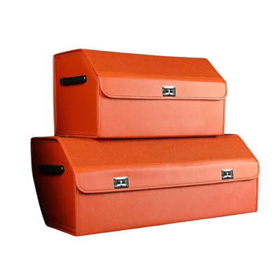 Two orange storage boxes stacked on a white background, with one smaller box on top of a larger one. Both boxes have a textured finish, black handles, and silver metal clasps.