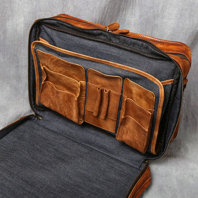 Open briefcase with brown interior pockets on a gray background