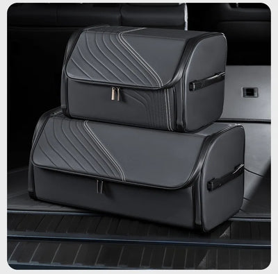 Two black car trunk organizer bags stacked inside a car trunk, featuring a textured chevron pattern and silver zipper pulls.