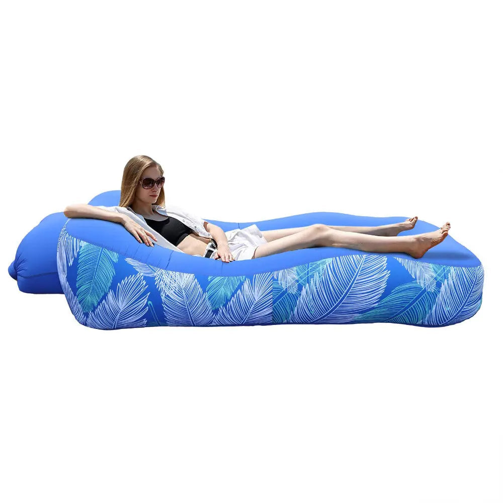 Blue inflatable lounge with leaf pattern, featuring a woman relaxing on it, with Otautau branding.