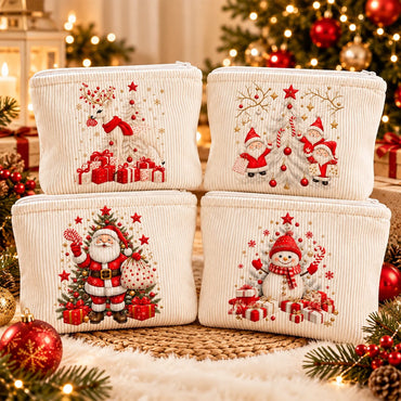 Four cream corduroy cosmetic pouches with embroidered Christmas designs, arranged in a 2x2 grid on a woven mat with festive holiday decorations in the background.