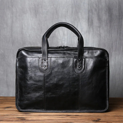 Black leather briefcase on a wooden surface with a gray background