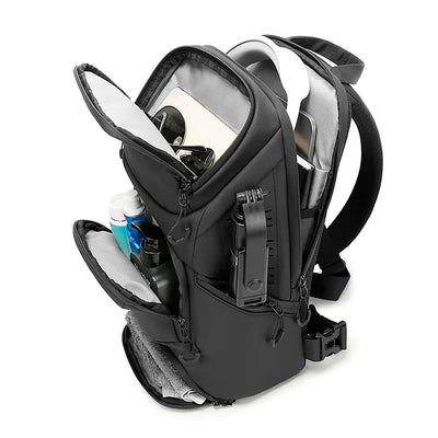 A black BANGE camera backpack shown open, filled with gear and accessories, on a white background.