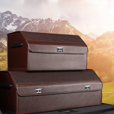 Two brown leatherette storage cases stacked on top of each other, shown against a scenic mountain landscape background.