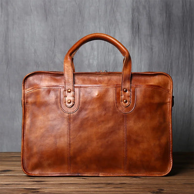 Brown leather briefcase on a wooden surface with a gray textured background
