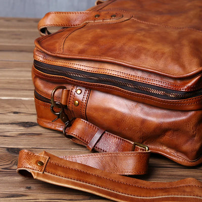 Brown leather bag with strap on a wooden surface