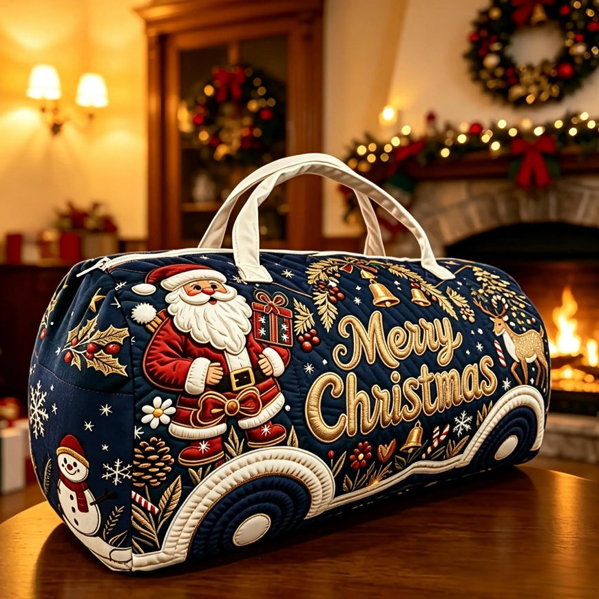 A navy blue Christmas-themed duffel bag with white handles, featuring embroidered or applique-style festive designs including Santa Claus, a gift box, reindeer, snowflakes, pinecones, and large gold 'Merry Christmas' lettering, set on a wooden table in a warmly lit holiday room.