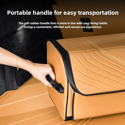 A tan faux-leather storage cube with a black handle and trim, shown with a hand holding the handle. White text at the top reads 'Portable handle for easy transportation' and describes the soft rubber handle.