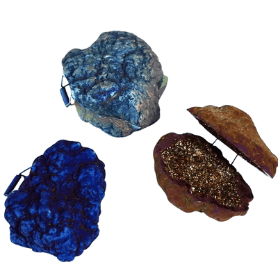 Three faux geode rock pouches on a plain white background, including one blue agate design, one deep blue design, and one brown geode with a gold glitter interior.