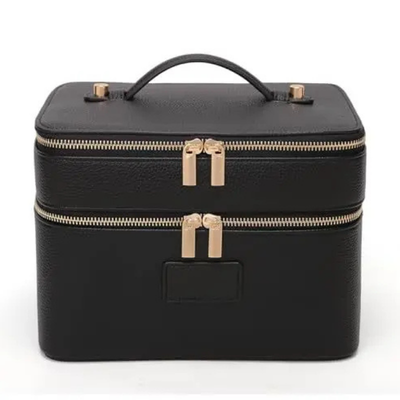 Black faux leather makeup case with a top handle, double zipper closure, and gold-tone hardware, shown on a plain white background.