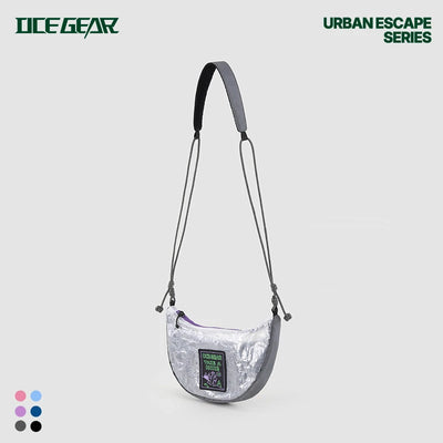 A metallic silver crescent-shaped shoulder bag with a black strap and a decorative front patch, shown against a light gray background with 'ICE GEAR' and 'URBAN ESCAPE SERIES' text.