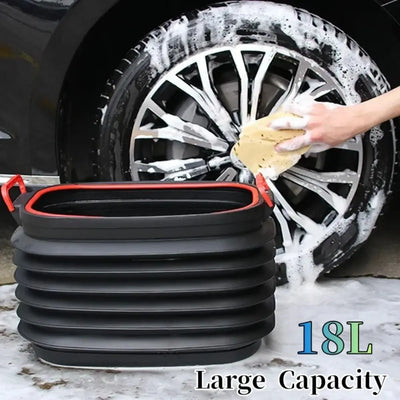 A large black collapsible plastic car wash bucket with red handles, shown in front of a car wheel being washed with soap and sponge. Text on the image reads '18L Large Capacity'.