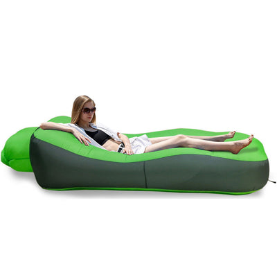A green and dark gray inflatable camping lounger with a woman reclining on it, shown on a white background with a small inset of the bag folded and dimensions labeled 19cm by 38cm. The brand name Otautau is visible in the top left.