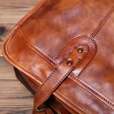 Close-up of a brown leather bag with visible stitching on a wooden surface