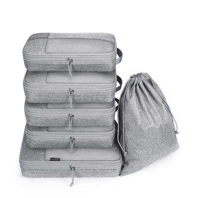 A set of five gray zippered packing cubes stacked vertically next to a matching gray drawstring bag, shown on a clean white background.