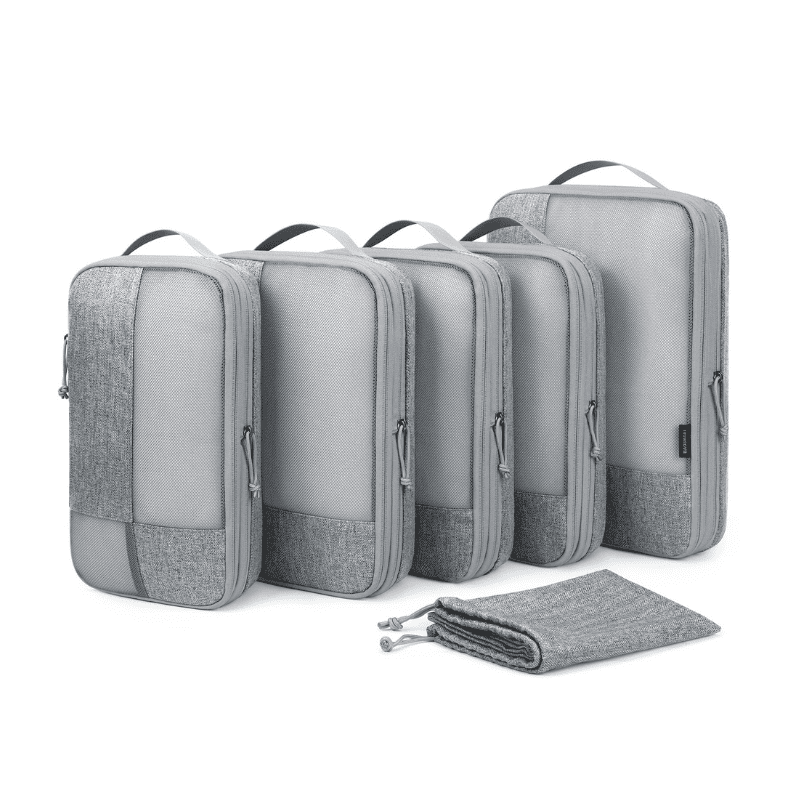 Five gray packing cubes of different sizes arranged in a row, with a matching gray drawstring pouch placed in front, on a clean white background.