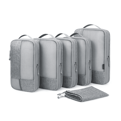 Five gray packing cubes of different sizes arranged in a row, with a matching gray drawstring pouch placed in front, on a clean white background.
